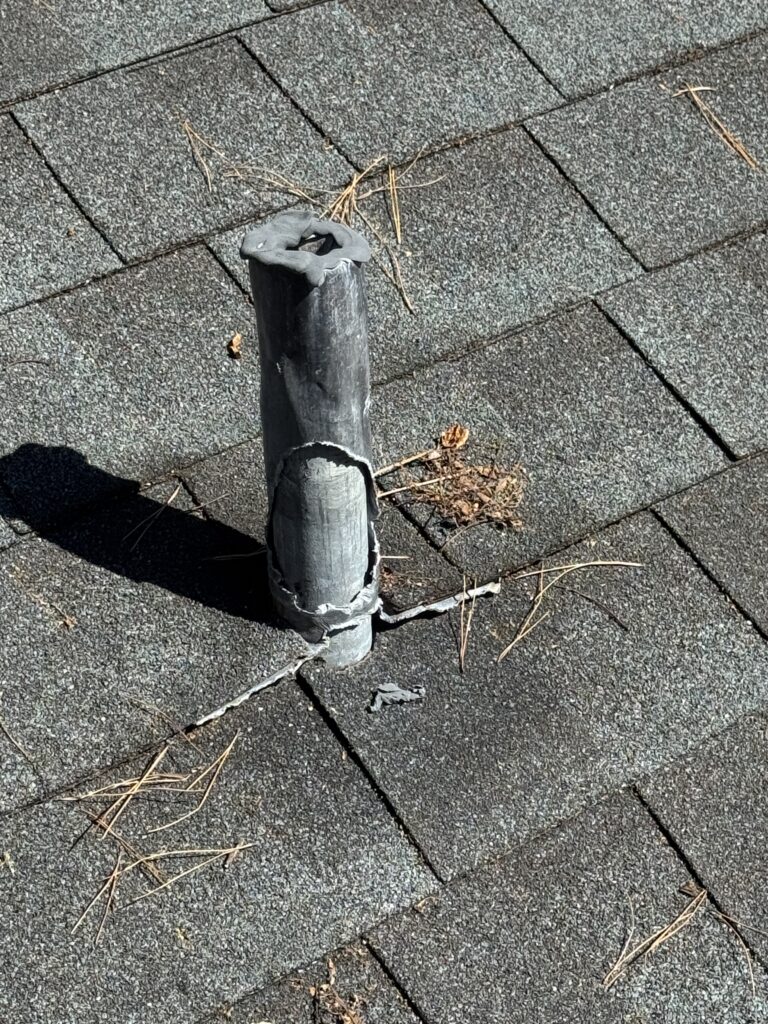 Deteriorated pipe boot on an older shingle roof, showing cracking and failure that allows water to enter the roof system.