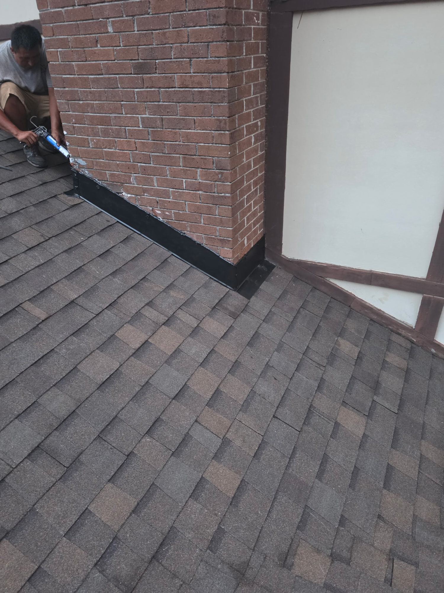 New black chimney flashing installed and sealed watertight against the brick