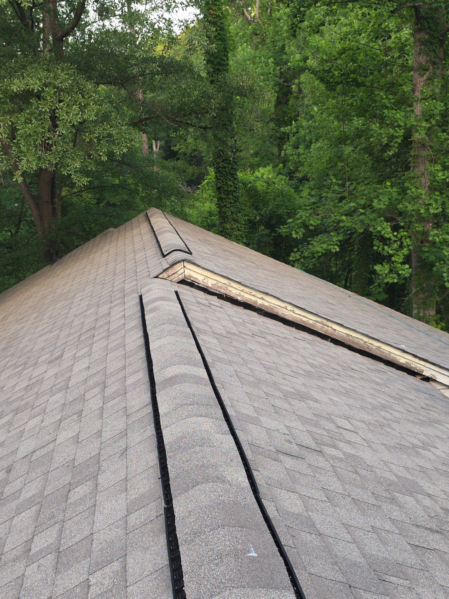 Finished: new architectural shingles running clean up to the peak with a new ridge vent installed for balanced attic ventilation