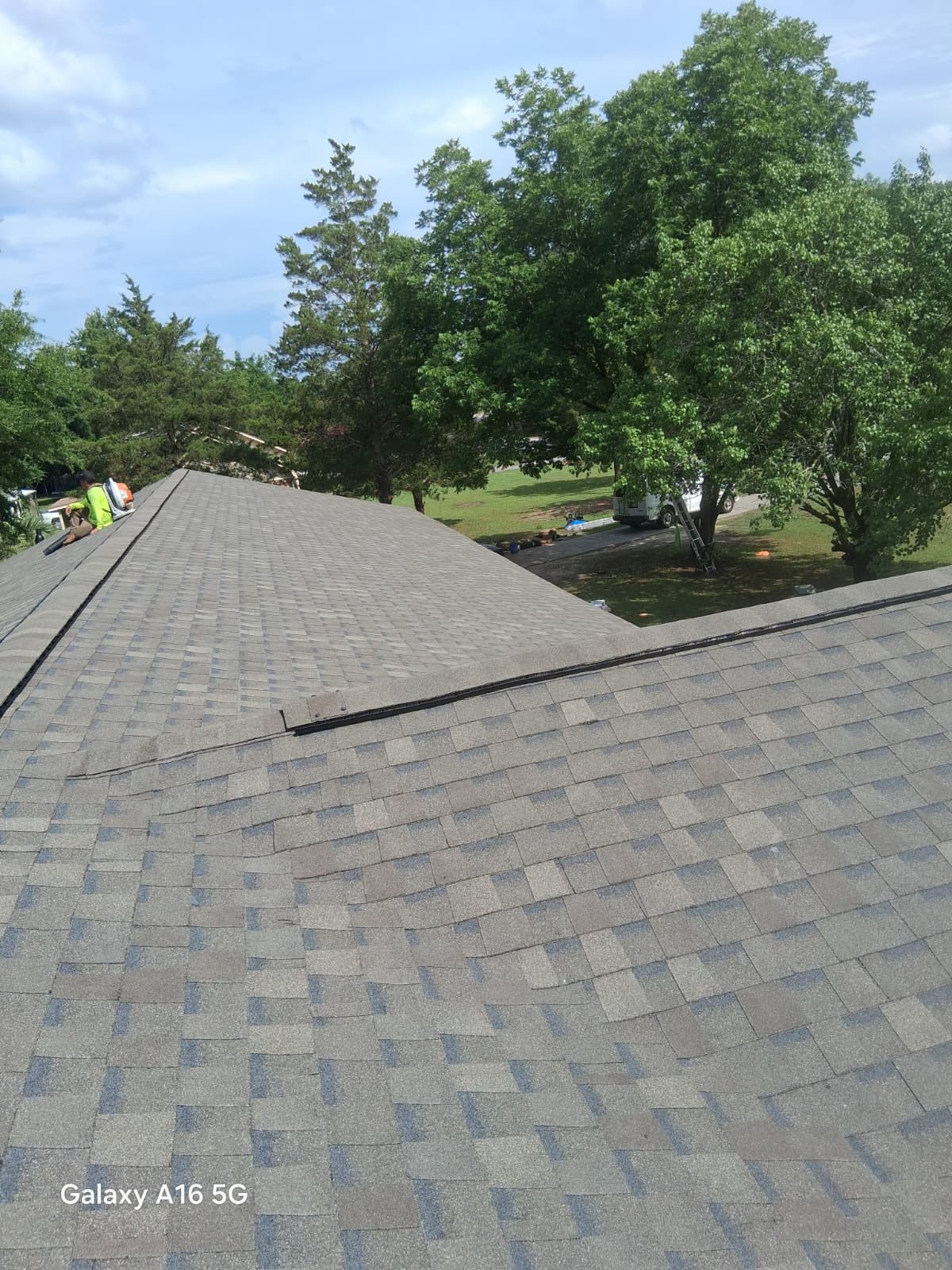 New architectural shingles going down across the front slope as the crew works up toward the ridge