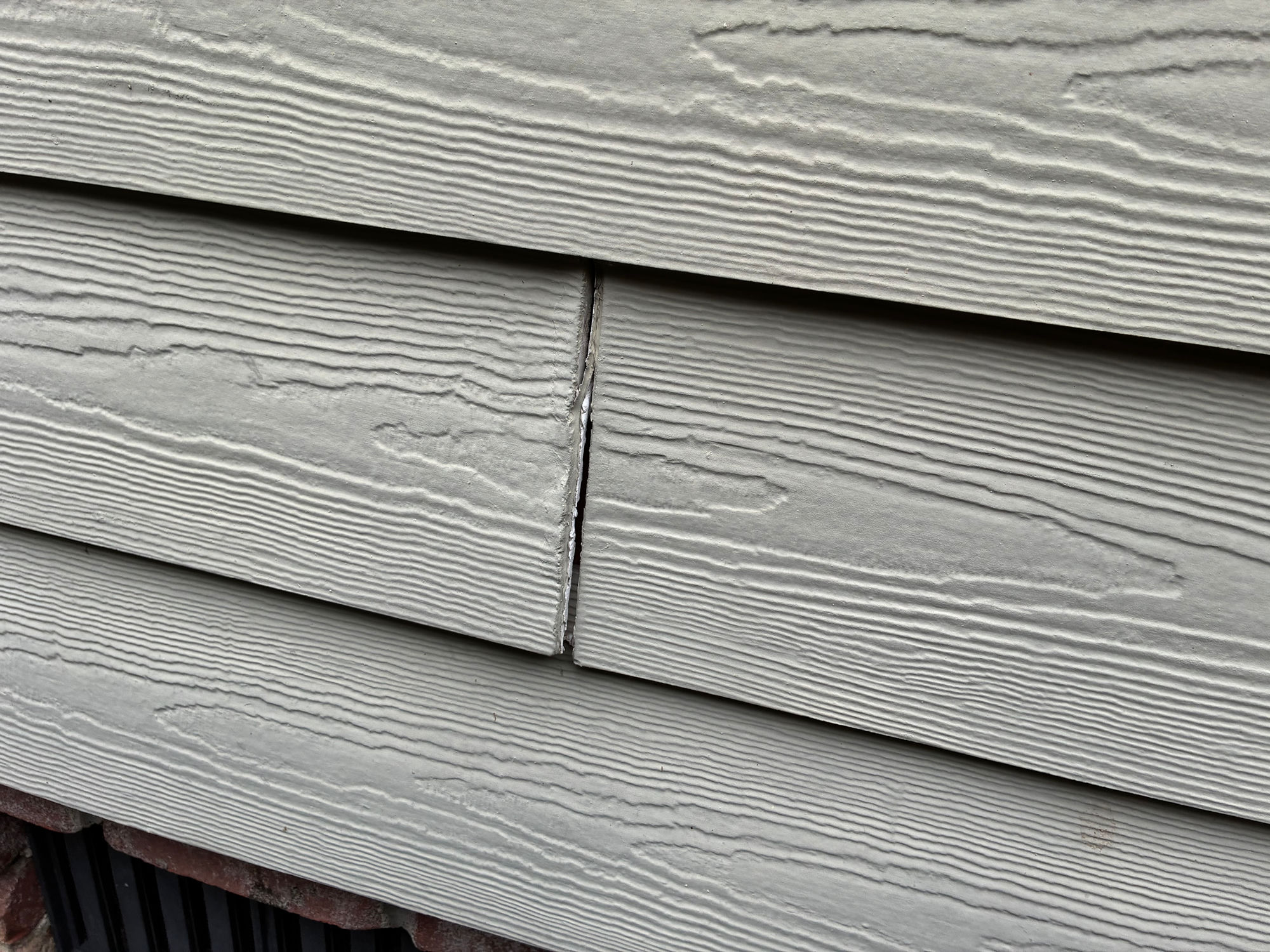 Cracked board letting moisture behind the siding