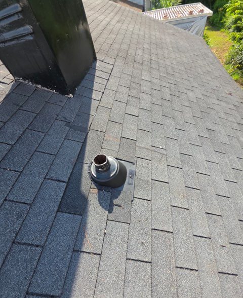 Repaired: new vent flashing set into the shingle courses beside the chimney chase, so water sheds
