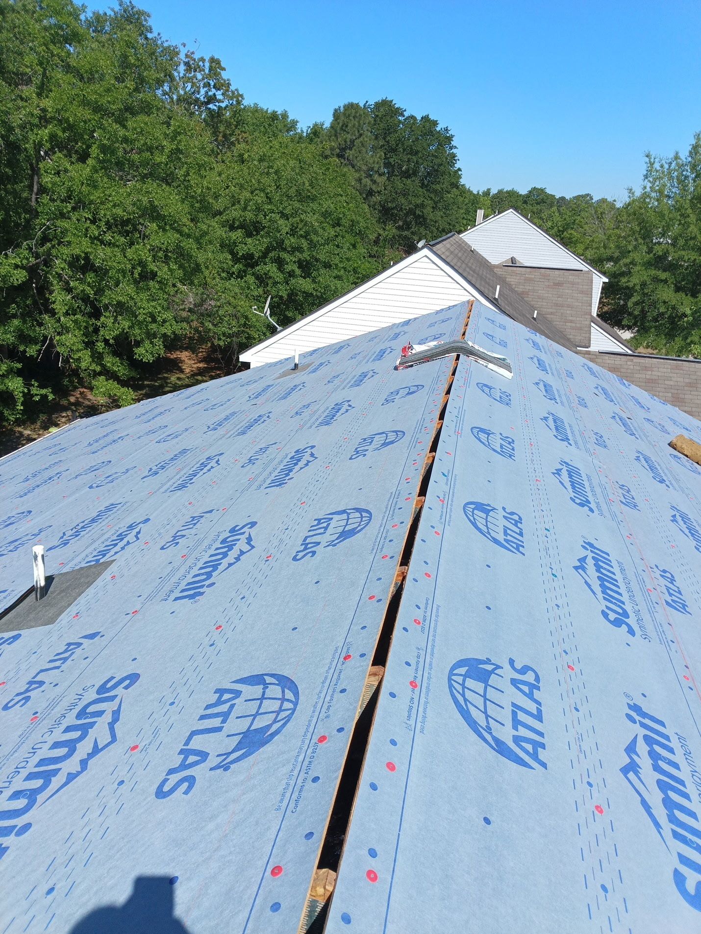 Installation underway: both slopes dried in and the ridge slot cut open the length of the peak, so