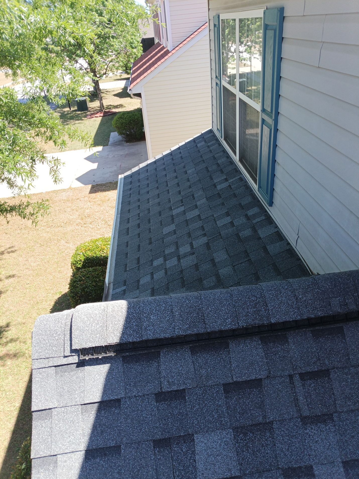 Finished: the lower porch slope re-shingled and worked in tight against the sidewall, with a clean,