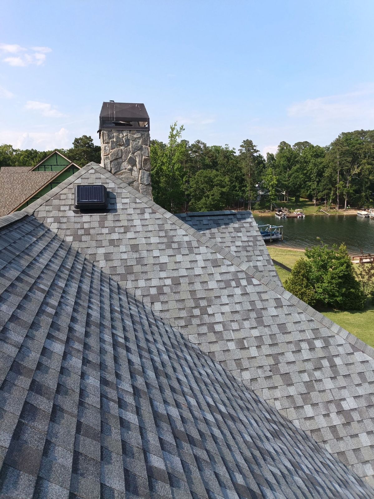 Finished: the new roof worked in tight around the stone chimney, with the solar attic vent set into