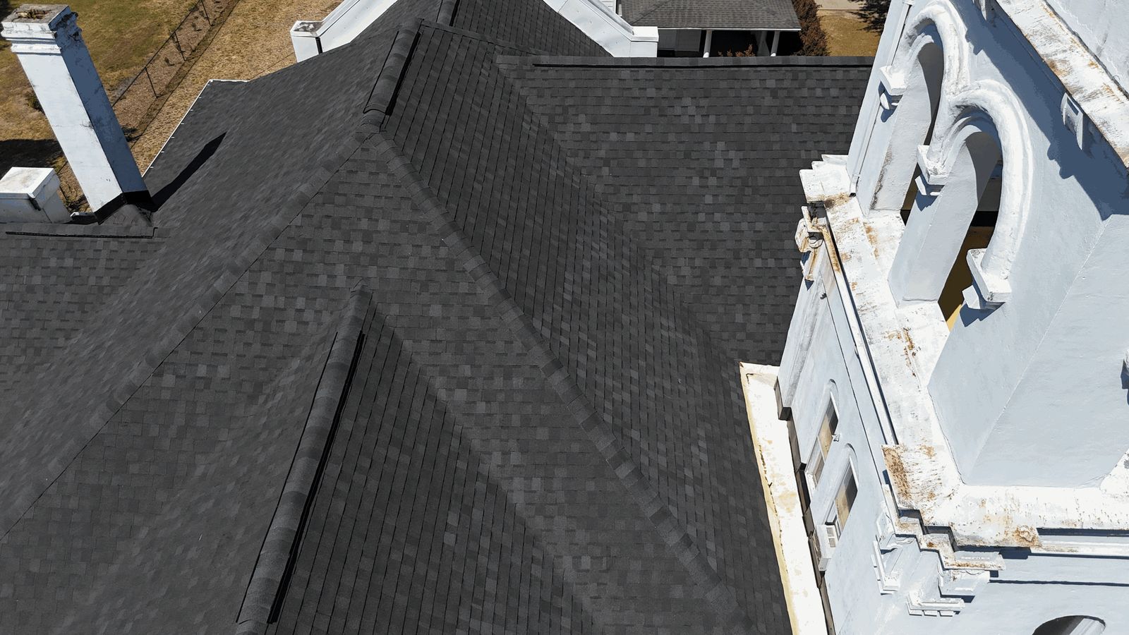 Finished: the new shingle field running up to the bell tower, every hip and ridge capped, with a