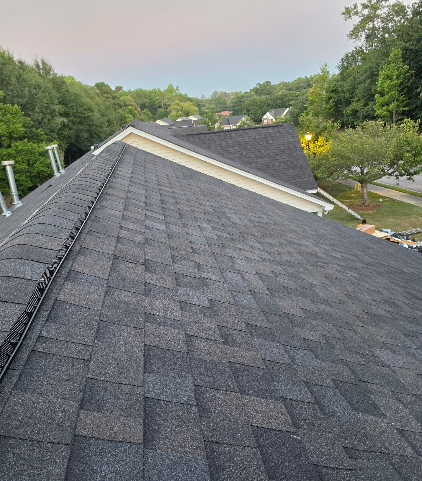Finished: new architectural shingles across the main slope, with a vented ridge running the full