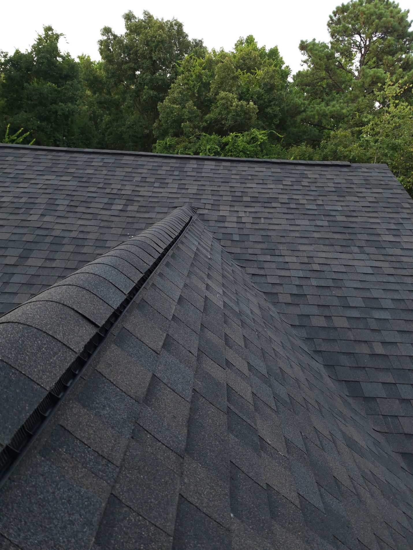 Finished: hip and ridge cap shingles laid over the new ridge vent — replacing the bare metal vent