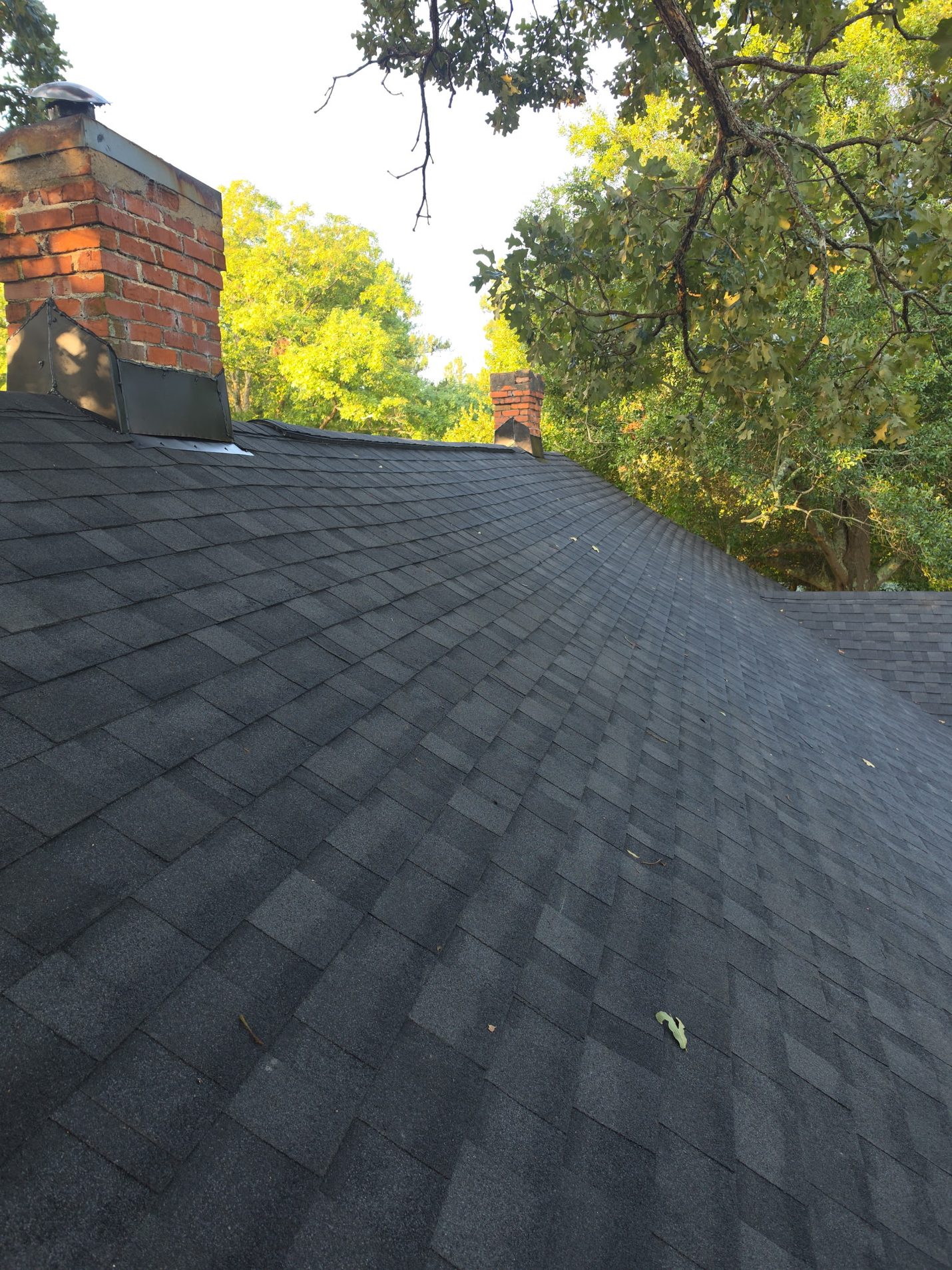 Finished: the front slope in new charcoal architectural shingles, with new flashing at the base of