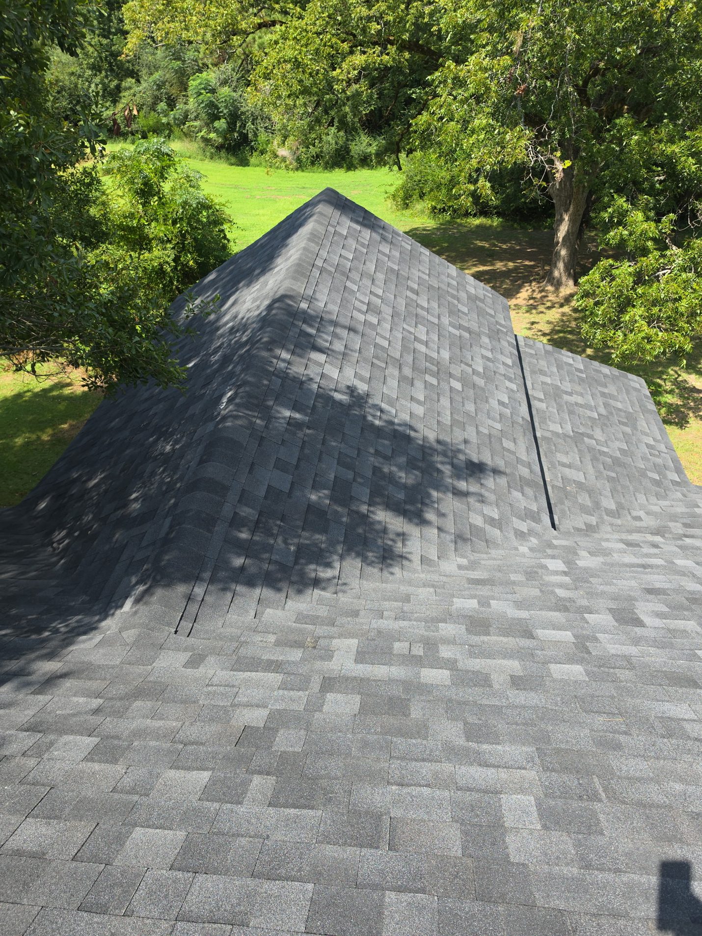 Finished: the hip roof over the rear addition in new architectural shingles, tied into the main roof